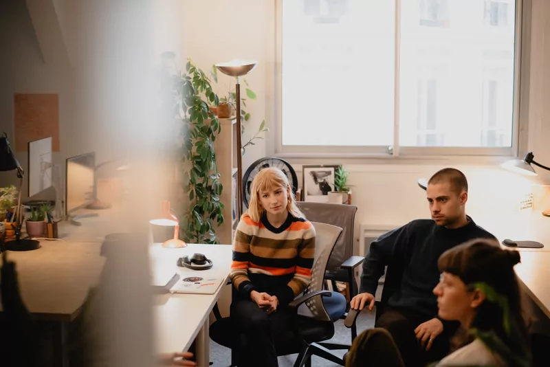 Informal meeting in Médianes offices: three people sitting near the window.